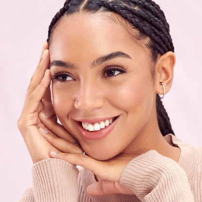 A woman with a natural makeup look, modeling false lashes in &