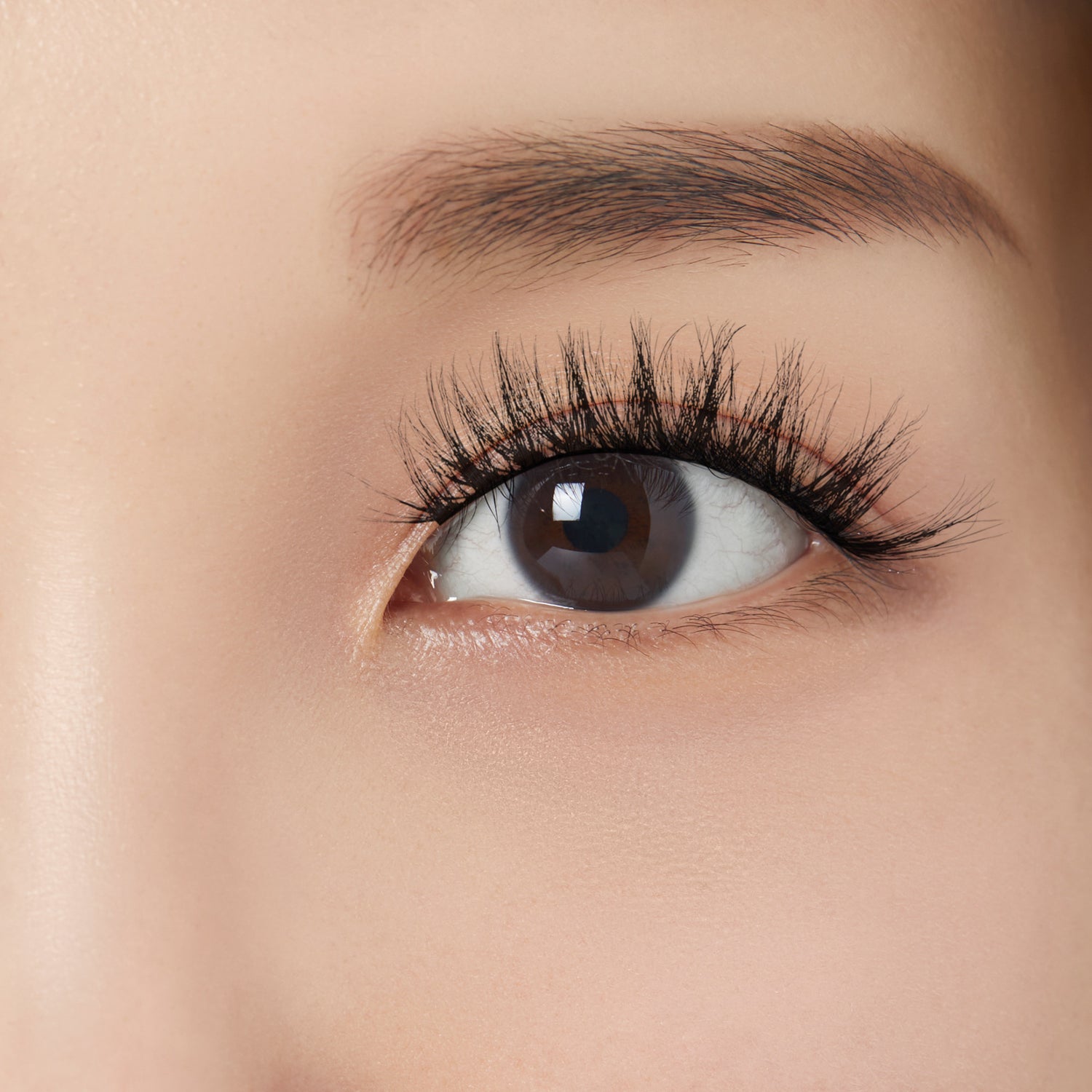 Close-up of a person with full, soft looking faux mink lashes. Lashes are &